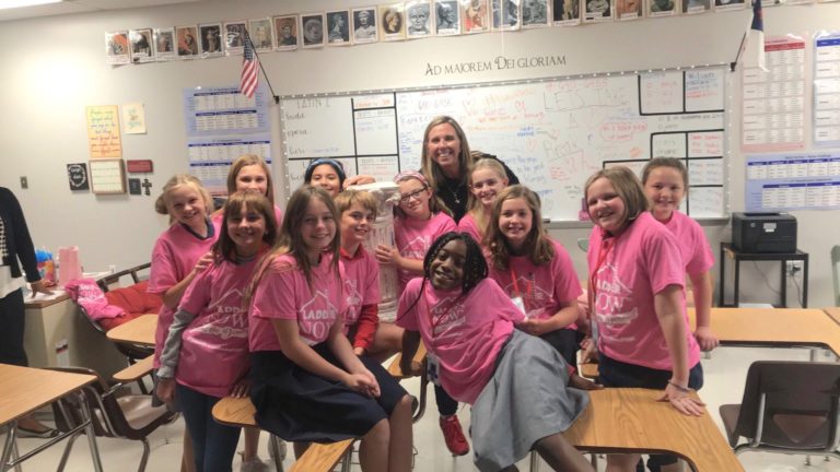 Kids in classroom wearing team green goes pink shirts